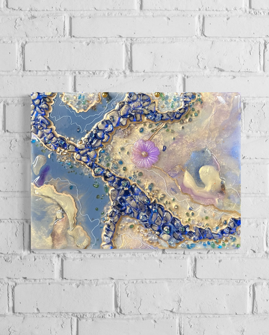 Epoxy resin geode abstract of pearl and blue colors with a purple flower in center hanging on a white brick wall