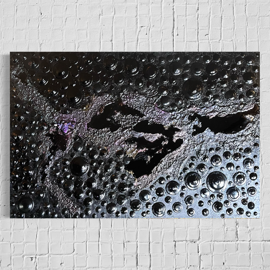 A rectangular abstract painting on canvas hanging on a white painted brick wall. The artwork features a dark black textured around epoxy smooth lakes