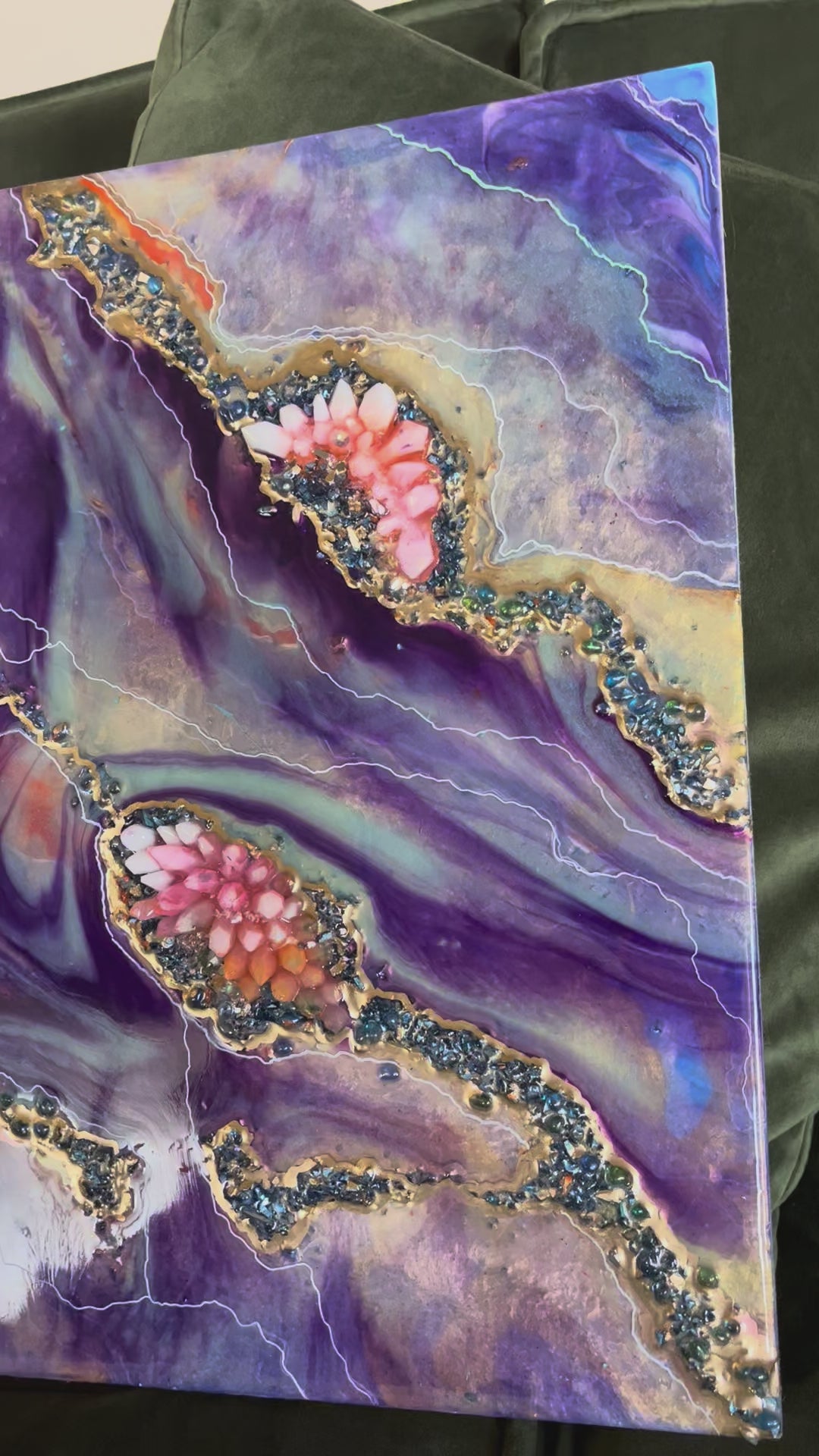 video of a purple and orange crystal geode epoxy piece sitting on a green couch
