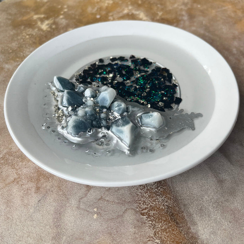 Grey Resin Crystal Cluster sitting on Black Crushed Glass angled view